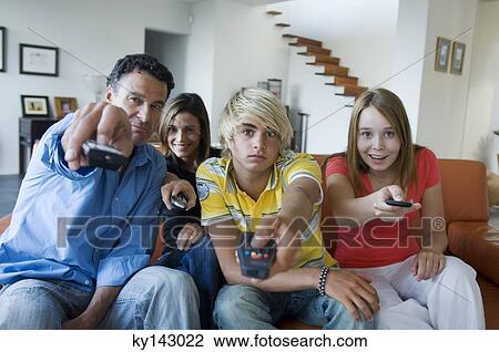 Parents and 2 teens using remote-controls View Large Photo Image Stock Image - Parents and 2 teens using remote-controls. Fotosearch