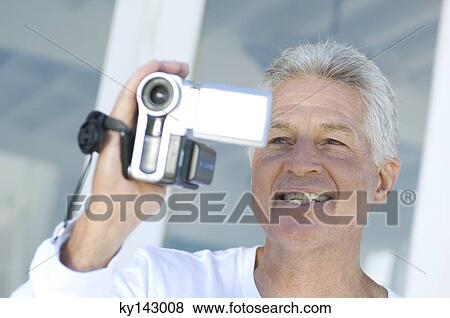 Portrait of a man using camcorder View Large Photo Image Stock Photo - Portrait of a man using camcorder. Fotosearch