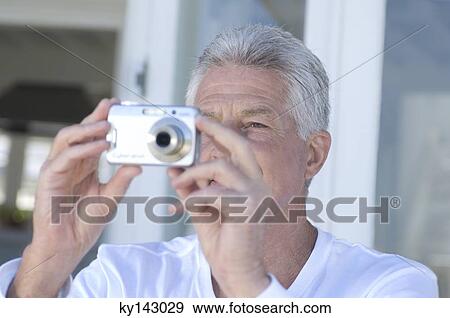 Stock Photo - Portrait of a man using digital camera. Fotosearch