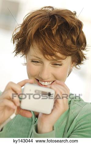 Portrait of a young woman using digital camera View Large Photo Image Picture - Portrait of a young woman using digital camera. Fotosearch