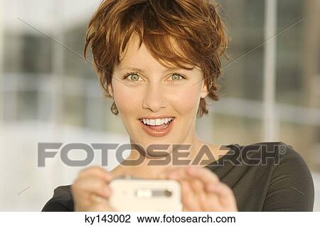 Portrait of a young woman using digital camera View Large Photo Image Stock Image - Portrait of a young woman using digital camera. Fotosearch