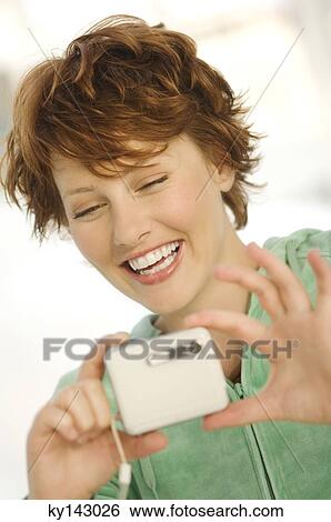 Portrait of a young woman using digital camera View Large Photo Image Stock Photograph - Portrait of a young woman using digital camera. Fotosearch