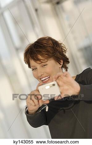 Portrait of a young woman using digital camera View Large Photo Image Stock Photography - Portrait of a young woman using digital camera. Fotosearch