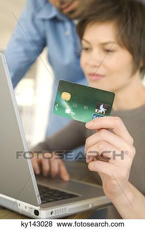 Stock Photo - Young couple using credit card on internet. Fotosearch