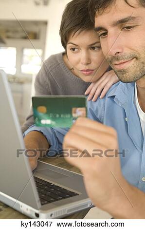 Young couple using credit card on internet View Large Photo Image Stock Photo - Young couple using credit card on internet. Fotosearch