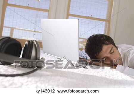 Young man sleeping in front of laptop View Large Photo Image Stock Image - Young man sleeping in front of laptop. Fotosearch