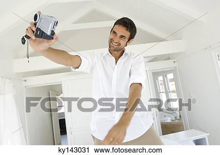 Young man using camcorder View Large Photo Image Stock Image - Young man using camcorder. Fotosearch