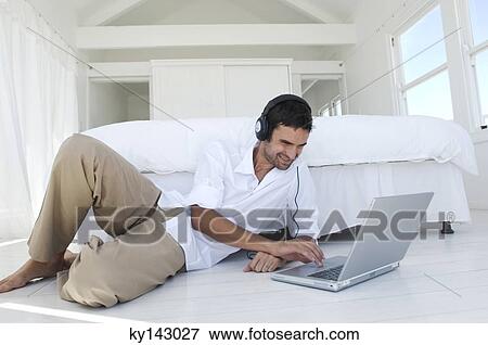 Young man using laptop View Large Photo Image Stock Photo - Young man using laptop. Fotosearch