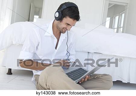 Young man using laptop View Large Photo Image Stock Photo - Young man using laptop. Fotosearch