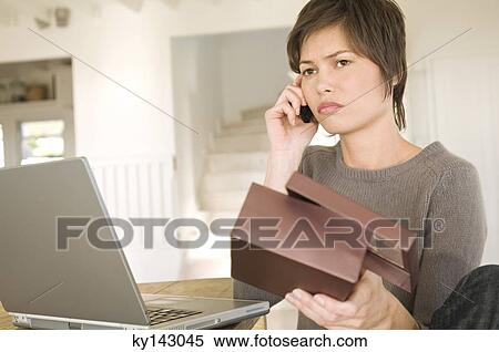Young woman with laptop, phoning, holding box View Large Photo Image Stock Photography - Young woman with laptop, phoning, holding box. Fotosearch