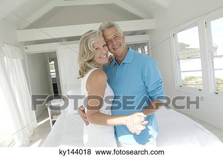 Couple embracing in bedroom View Large Photo Image Stock Photo - Couple embracing in bedroom. Fotosearch