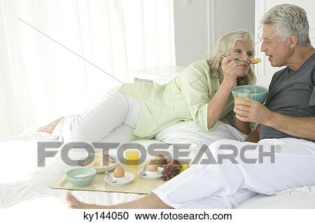 Couple having breakfast in bed View Large Photo Image Stock Image - Couple having breakfast in bed. Fotosearch