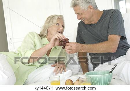 Couple having breakfast in bed View Large Photo Image Stock Image - Couple having breakfast in bed. Fotosearch