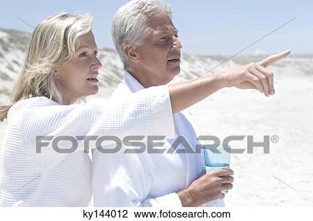 Stock Image - Couple in bathrobe on the beach. Fotosearch