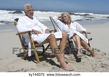 Couple in bathrobe, sitting on beach chairs View Large Photo Image Stock Photography - Couple in bathrobe, sitting on beach chairs. Fotosearch