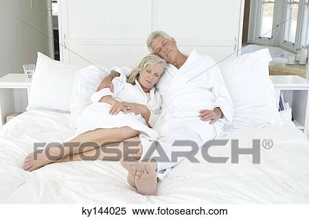 Couple in bathrobe sleeping in bed View Large Photo Image Stock Photography - Couple in bathrobe sleeping in bed. Fotosearch