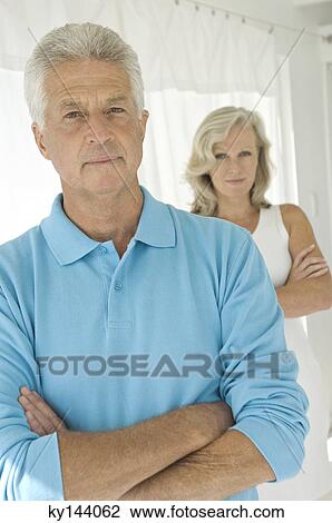 Couple with arms crossed, looking at camera View Large Photo Image Stock Image - Couple with arms crossed, looking at camera. Fotosearch