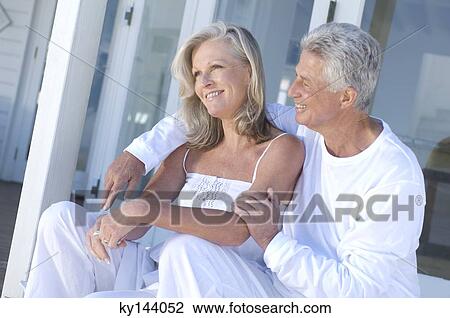 Embracing couple sitting on terrace View Large Photo Image Stock Image - Embracing couple sitting on terrace. Fotosearch