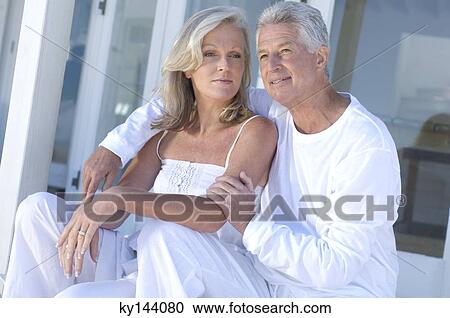 Embracing couple sitting on terrace View Large Photo Image Stock Image - Embracing couple sitting on terrace. Fotosearch