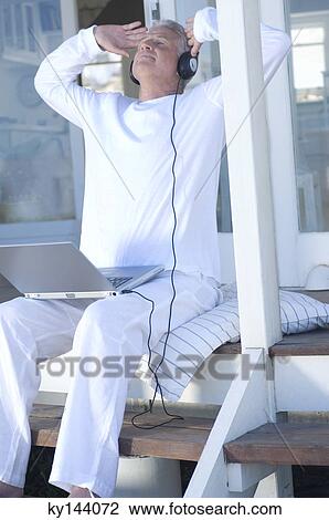 Man listening to music with laptop, arms in the air View Large Photo Image Stock Image - Man listening to music with laptop, arms in the air. Fotosearch
