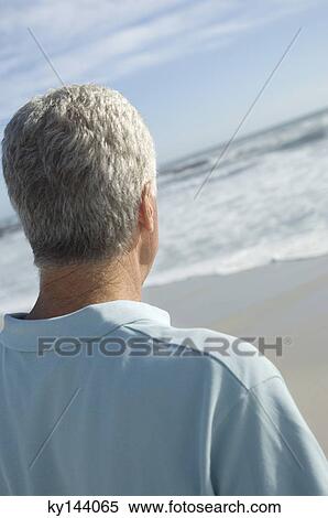 Man looking out to sea, rear view View Large Photo Image Stock Photography - Man looking out to sea, rear view. Fotosearch
