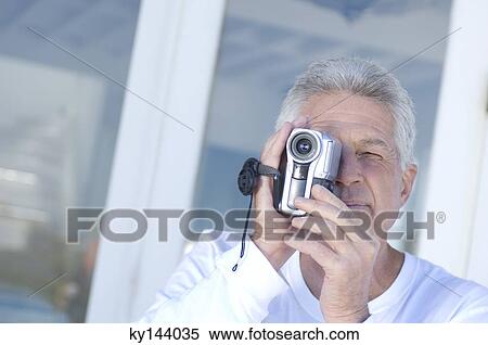 Man using camcorder View Large Photo Image Stock Photography - Man using camcorder. Fotosearch