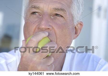 Portrait of man eating an apple View Large Photo Image Stock Image - Portrait of man eating an apple. Fotosearch