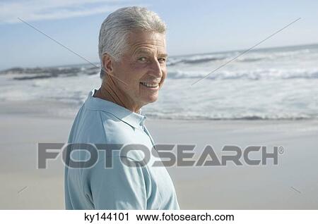 Portrait of man on the beach, smiling for the camera View Large Photo Image Stock Image - Portrait of man on the beach, smiling for the camera. Fotosearch