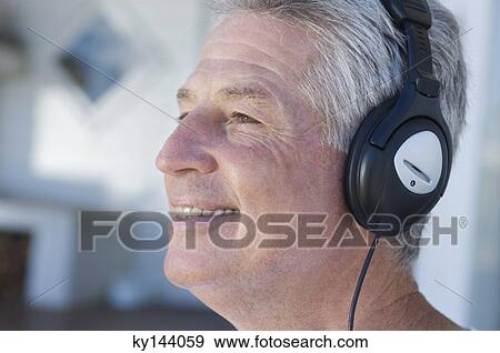Portrait of smiling man listening to music with headphones View Large Photo Image Stock Photo - Portrait of smiling man listening to music with headphones. Fotosearch