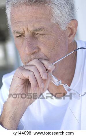 Portrait of thinking man holding eyeglasses View Large Photo Image Stock Photo - Portrait of thinking man holding eyeglasses. Fotosearch