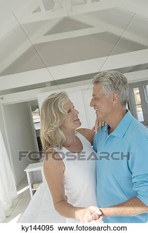Smiling couple embracing in bedroom View Large Photo Image Stock Photography - Smiling couple embracing in bedroom. Fotosearch