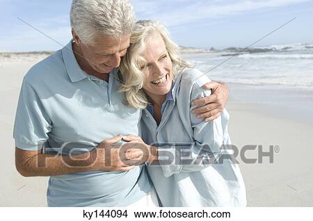 Smiling couple embracing on the beach View Large Photo Image Picture - Smiling couple embracing on the beach. Fotosearch