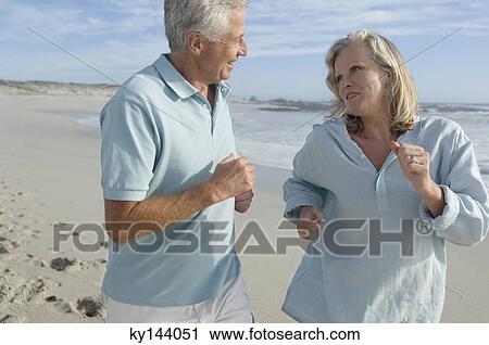 Smiling couple running on the beach View Large Photo Image Stock Image - Smiling couple running on the beach. Fotosearch