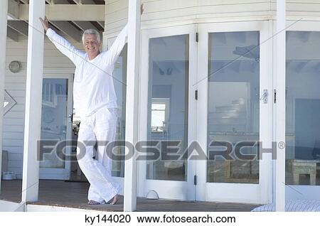 Smiling man standing on wooden terrace View Large Photo Image Stock Image - Smiling man standing on wooden terrace. Fotosearch