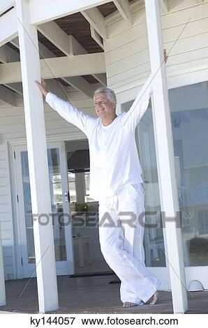 Smiling man standing on wooden terrace View Large Photo Image Stock Photo - Smiling man standing on wooden terrace. Fotosearch