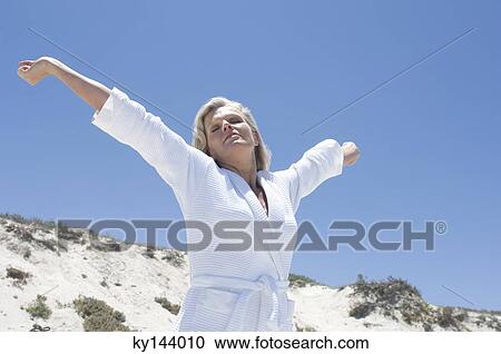Woman in bathrobe, stretching on the beach View Large Photo Image Stock Image - Woman in bathrobe, stretching on the beach. Fotosearch
