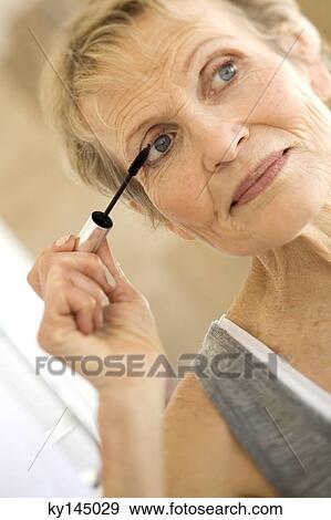 Senior woman applying mascara View Large Photo Image Stock Photo - Senior woman applying mascara. Fotosearch