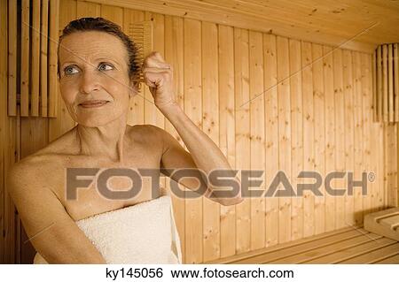 Senior woman combing her hair in sauna View Large Photo Image Stock Photograph - Senior woman combing her hair in sauna. Fotosearch