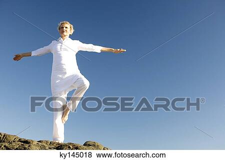 Senior woman doing yoga on beach View Large Photo Image Stock Photo - Senior woman doing yoga on beach. Fotosearch