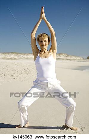 Senior woman doing yoga on the beach View Large Photo Image Stock Image - Senior woman doing yoga on the beach. Fotosearch