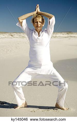 Senior woman doing yoga on the beach View Large Photo Image Stock Photograph - Senior woman doing yoga on the beach. Fotosearch