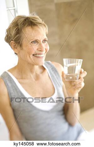 Senior woman holding glass of water View Large Photo Image Stock Photo - Senior woman holding glass of water. Fotosearch