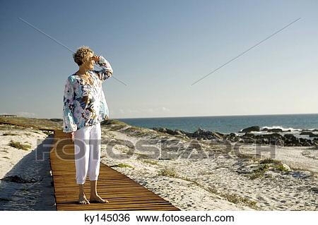 Stock Photograph - Senior woman looking out to sea. Fotosearch