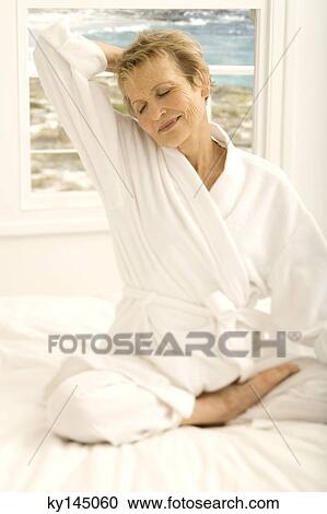 Senior woman sitting cross-legged on bed View Large Photo Image Stock Image - Senior woman sitting cross-legged on bed. Fotosearch