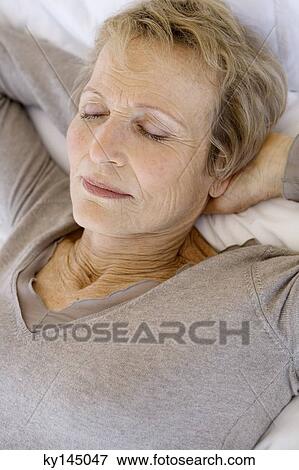 Senior woman sleeping, hands behind head View Large Photo Image Stock Photo - Senior woman sleeping, hands behind head. Fotosearch