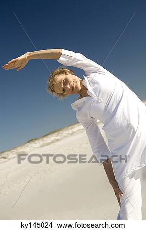 Senior woman stretching on beach View Large Photo Image Picture - Senior woman stretching on beach. Fotosearch