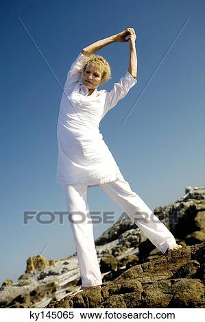 Senior woman stretching on beach View Large Photo Image Stock Photography - Senior woman stretching on beach. Fotosearch