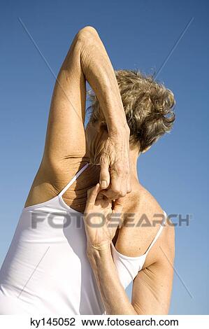 Stock Image - Senior woman stretching, rear view. Fotosearch