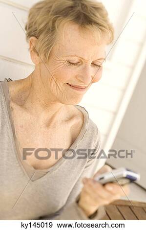 Stock Photo - Senior woman using mobile phone. Fotosearch