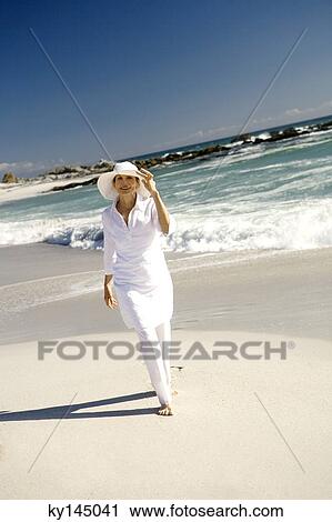 Senior woman walking on beach View Large Photo Image Stock Image - Senior woman walking on beach. Fotosearch